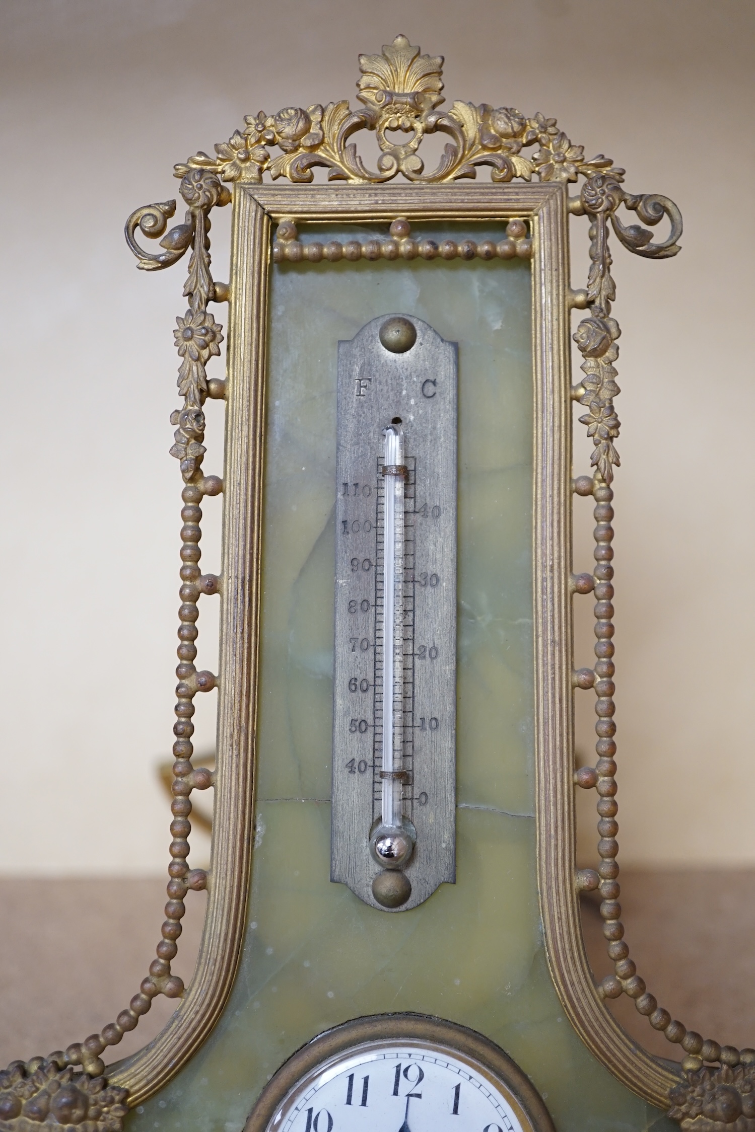 An onyx and gilt metal easel timepiece and thermometer, 20cm high. Condition - fair